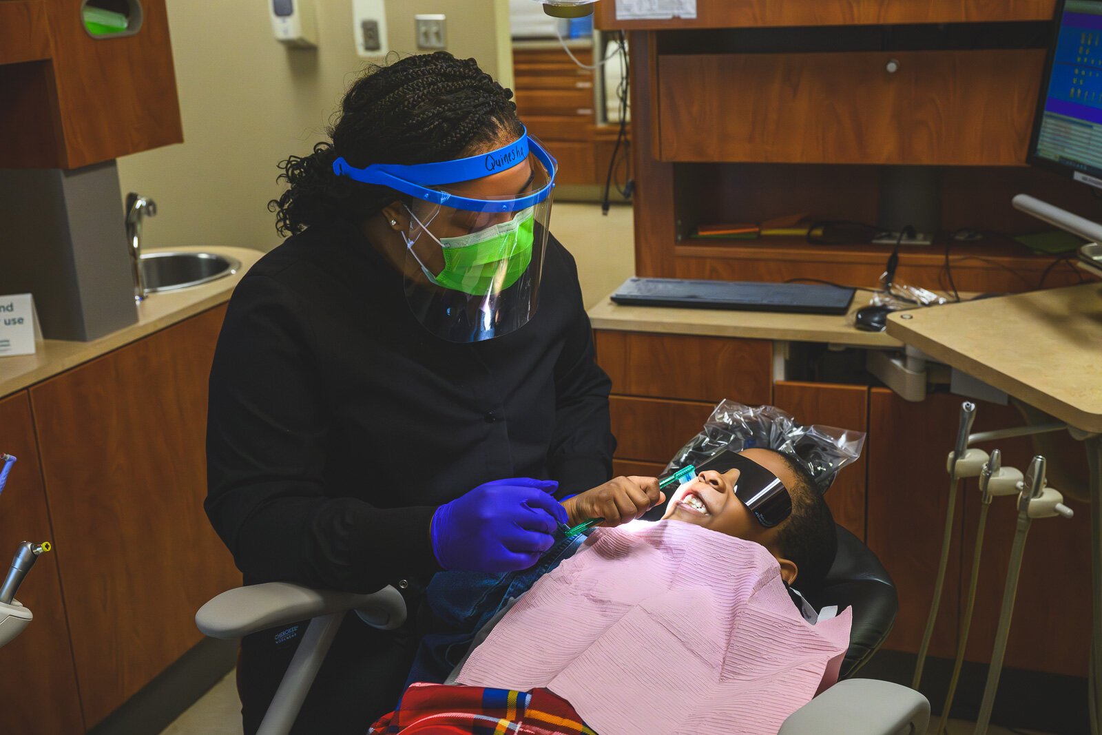Dental hygienist Quinesha Brewer shows Giovanni how to brush.