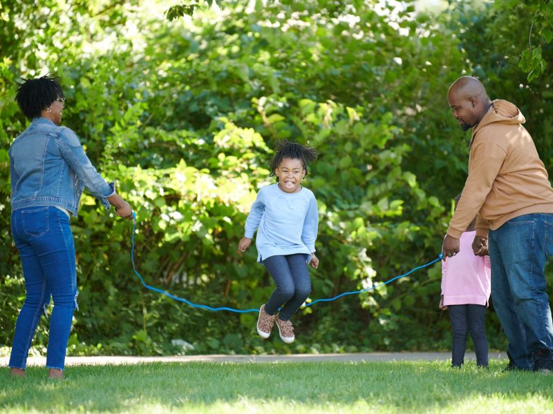 A family enjoys jump roping along the Lansing River Trail.