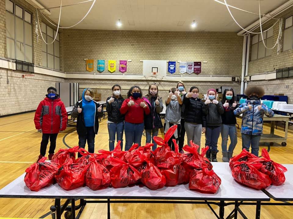Students with a pile of "red bags" of produce.