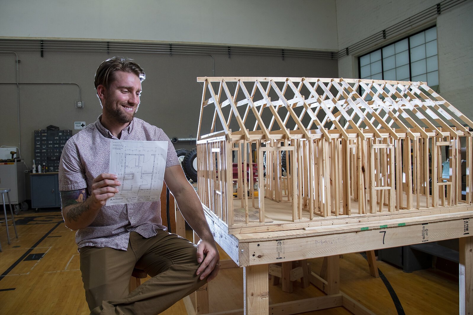 Kyle Jelens showing off his students' work inside of the woodshop.