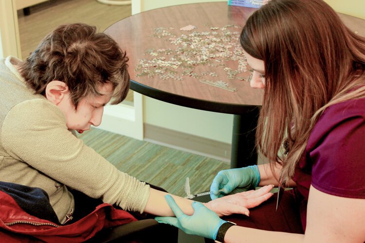 Mary Nyitray (left) has blood drawn by LPN Kelly Milanowski at the LifeCircles PACE Hub in Holland Township. 