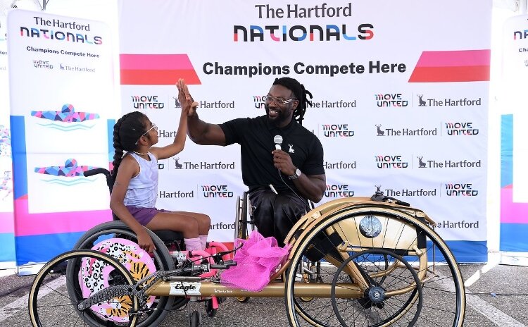 Paralympic gold medalist Matt Scott gifted a track chair to Divya Harkema, 12, of Grandville.