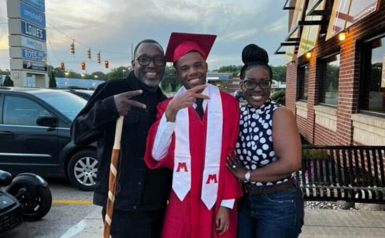 Aaron Allen with his parents, Tamica Sain and LeShawn Savage, at his high school graduation.