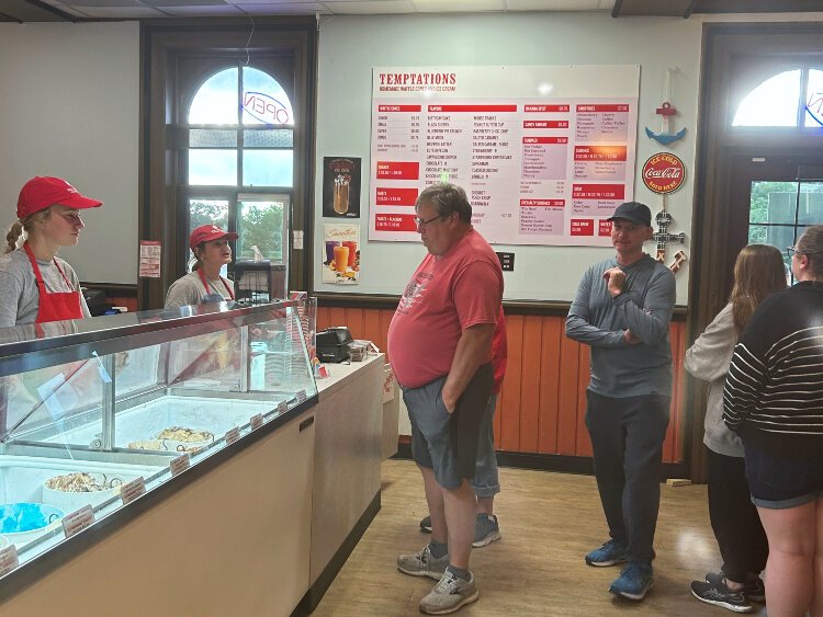 Customers wait to place their orders inside Sweet Temptations ice cream shop.