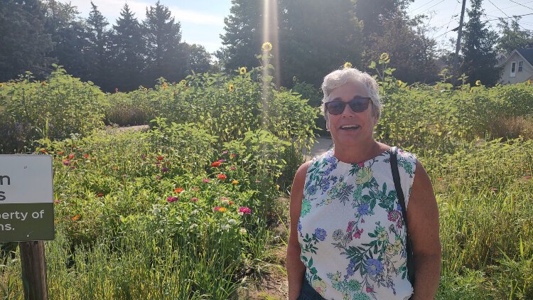 Neighborhood Connector Lori Appeldoorn is nearly as tall as the plants at the corner garden near Central Avenue and State Street. The garden will become a community effort soon.