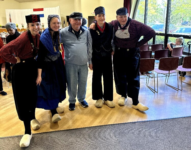 A Tulip Time visitor gets his photo take with the Evergreen Commons Dutch Dancers.