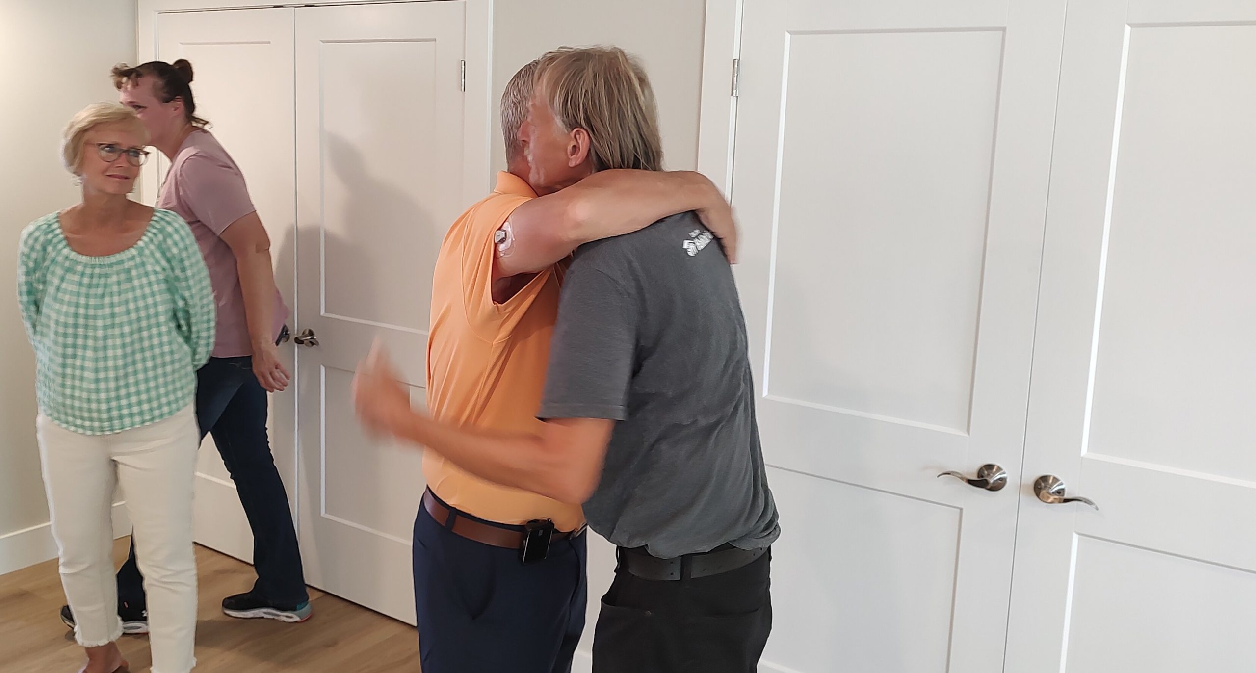 A well-wisher hugs future homeowner John, right, who is one of five selected for Lakeshore Habitat for Humanity's Haven Townhomes, specifically geared toward single adults with disabilities.