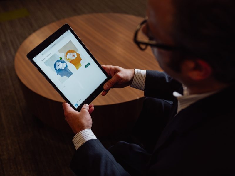 Dr. Jordan Braciszewski demonstrates an iPad app used to screen children for mental health issues in Henry Ford Health clinics.