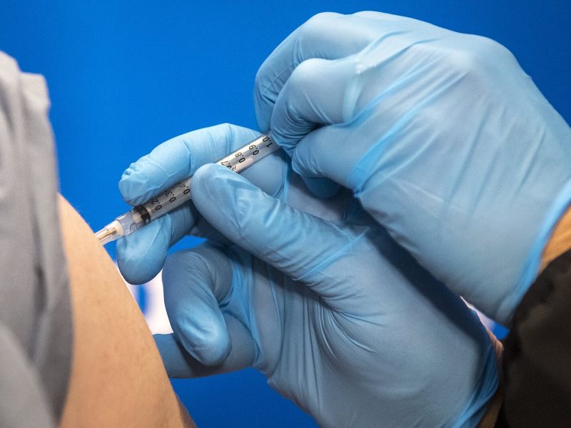 Carolyn Wilson administers the first dose of the COVID-19 vaccine to Dr. Eric Kane at Beaumont Service Center in Southfield on Dec. 15, 2020.