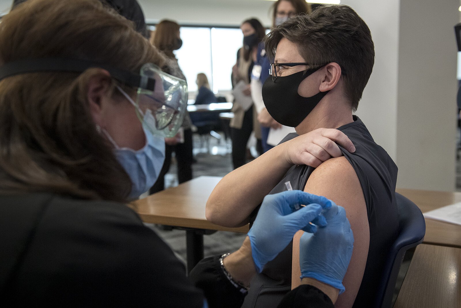 Susan Grant administers the first dose of the COVID-19 vaccine to phlebotomist Valerie Gullet at Beaumont Service Center in Southfield on Dec. 15, 2020.