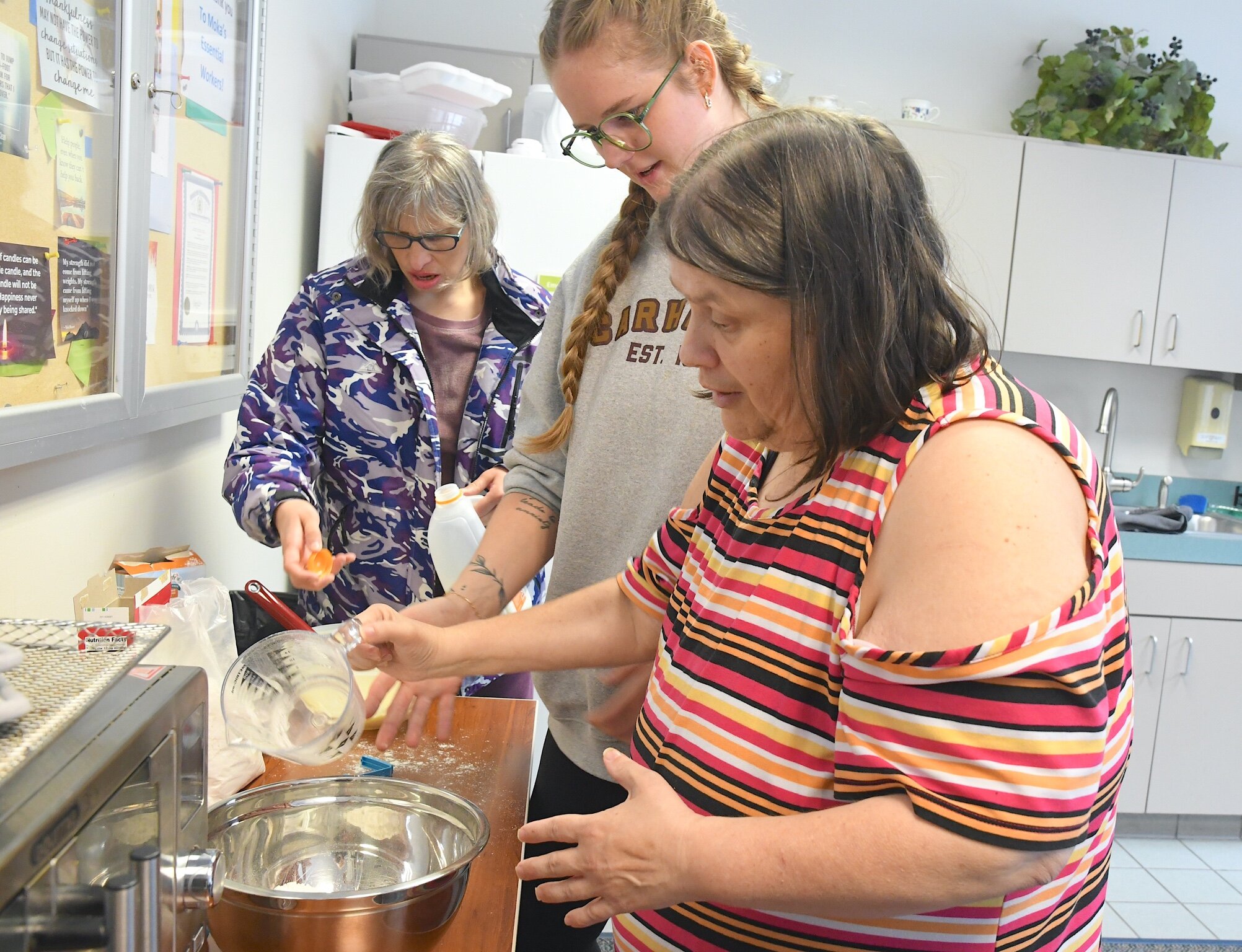 Natalie Visser, an assistant supervisor for MOKA, works with, Stacy, left, and Juanita.