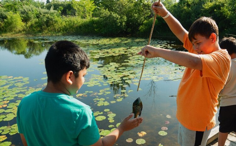 Two boys fish during ODC’s “Best of Summer” event at Lake Hills Elementary.