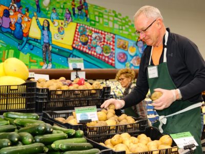 A volunteer stocks the food club at Community Action House in Holland, Mich.