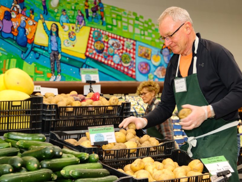 A volunteer stocks the food club at Community Action House in Holland, Mich.